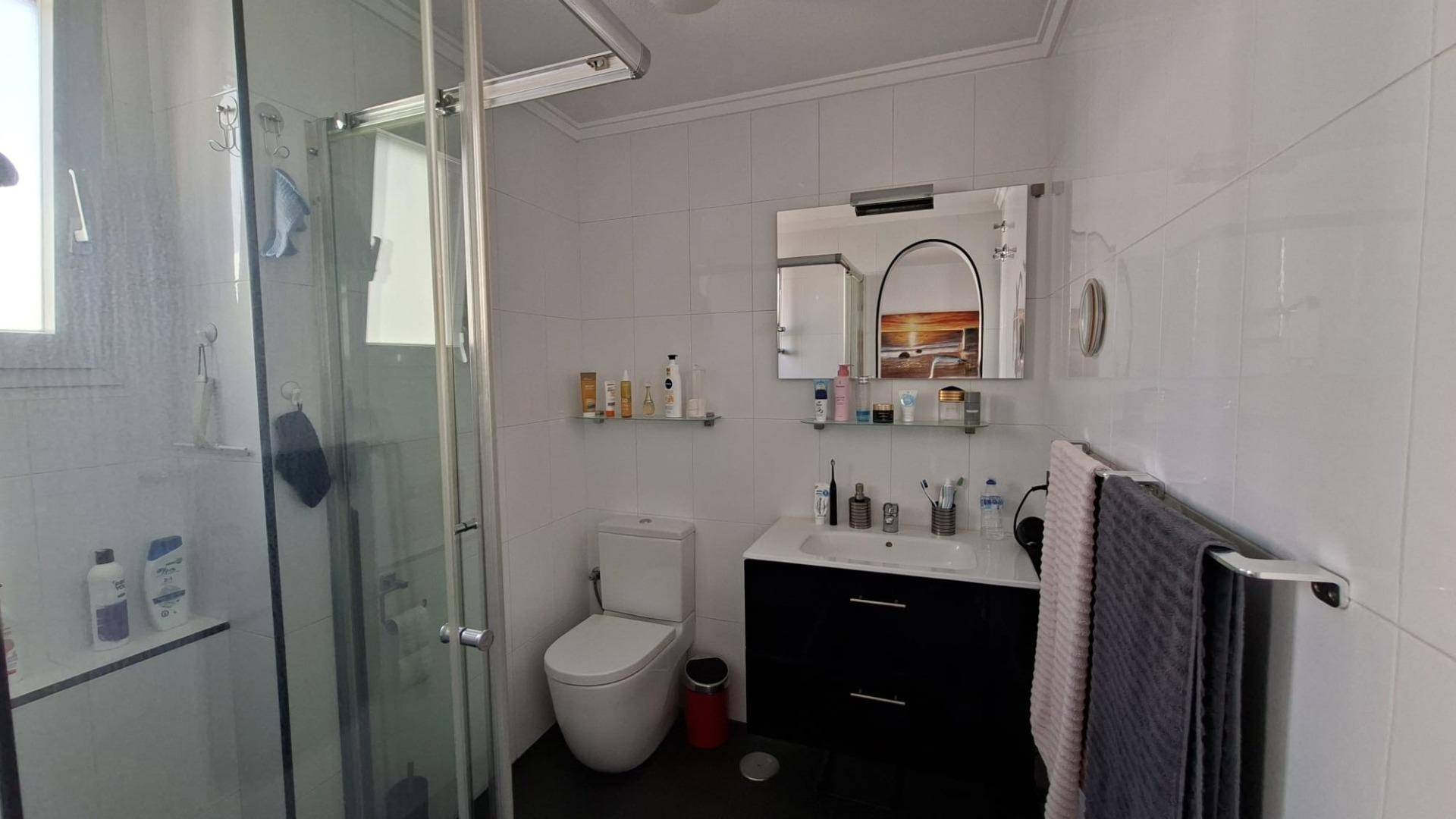Bathroom vanity unit and mirror in tiled bathroom, Acequion apartment
